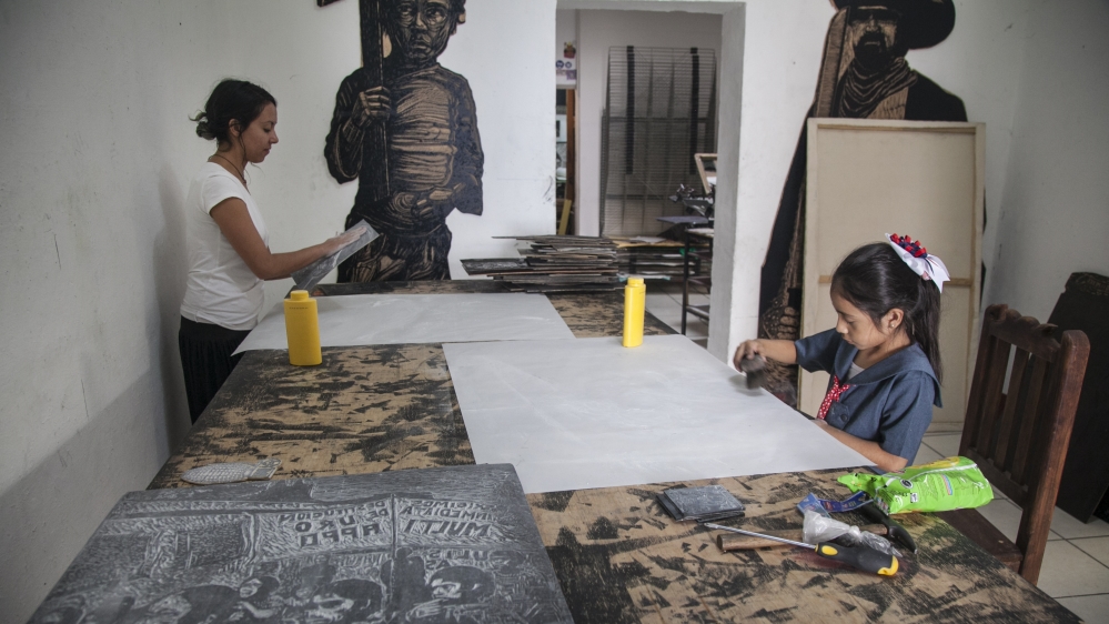 
Friends and family finishing prints at Espacio Zapata [Gabriela Campos/Al Jazeera] 
