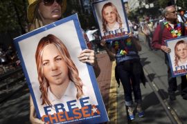 FILE PHOTO -- People hold signs calling for the release of imprisoned wikileaks whistleblower Chelsea Manning while marching in a gay pride parade in San Francisco, California