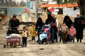 Displaced Iraqi families who fled from clashes during a battle between Iraqi forces and Islamic State militants walk with their children in Mosul
