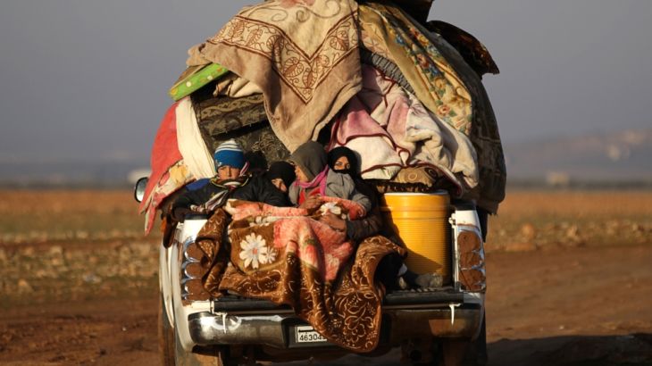 People ride a vehicle stacked with their belongings after fleeing clashes in the northern Syrian town of al-Bab