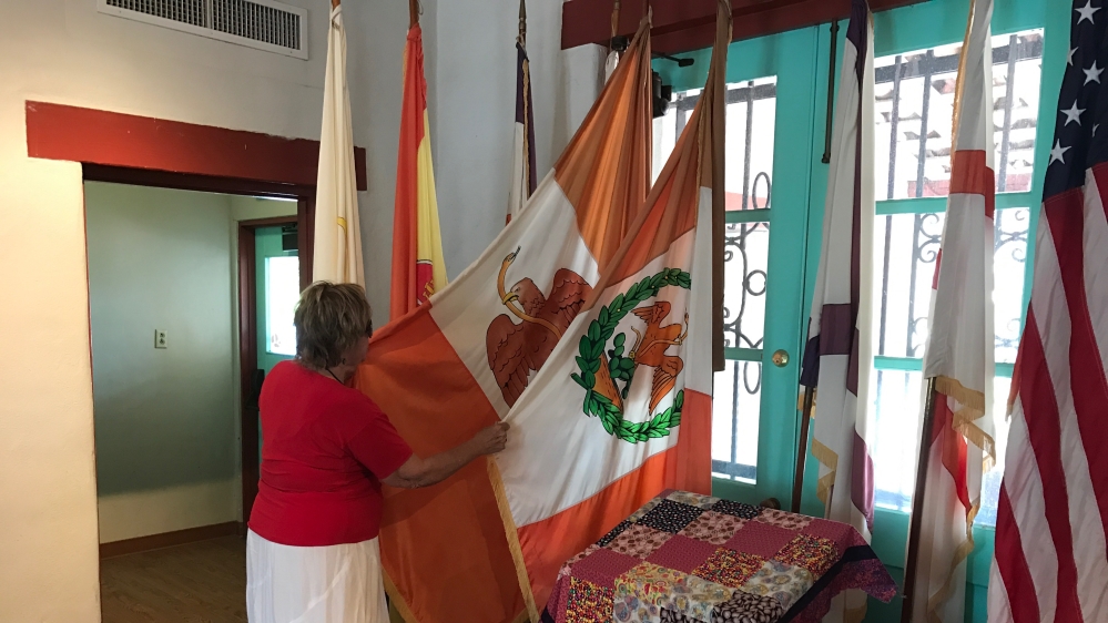 Beth Perrin, historical society member, shows Al Jazeera the two Mexican flags that have flown over this space [Massoud Hayoun/Al Jazeera]