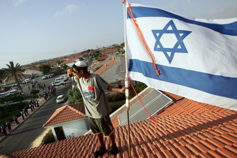 Jewish boy waving an Israeli flag in an illegal settlement