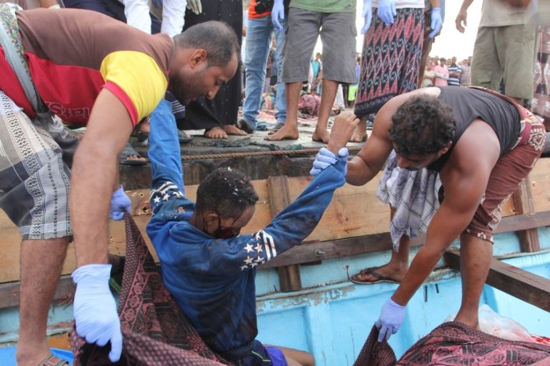Yemeni fishermen carry the body of a Somali refugee, killed in attack by a helicopter while travelling in a vessel off Yemen, are pictured at the Red Sea port of Hodeidah, Yemen