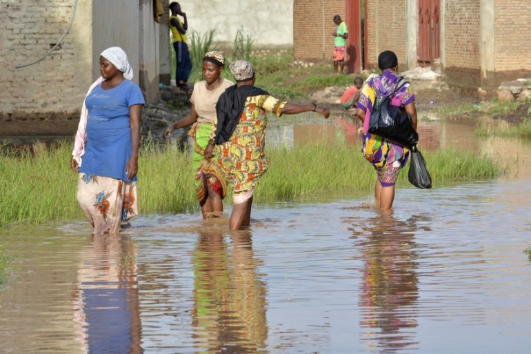 Women walk through muddy floodwaters in Buterere, northwest of Bujumbura