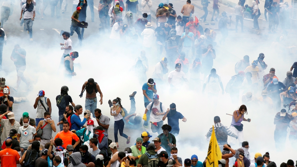 Police fired tear gas at the anti-Maduro protesters [Christian Veron/Reuters]