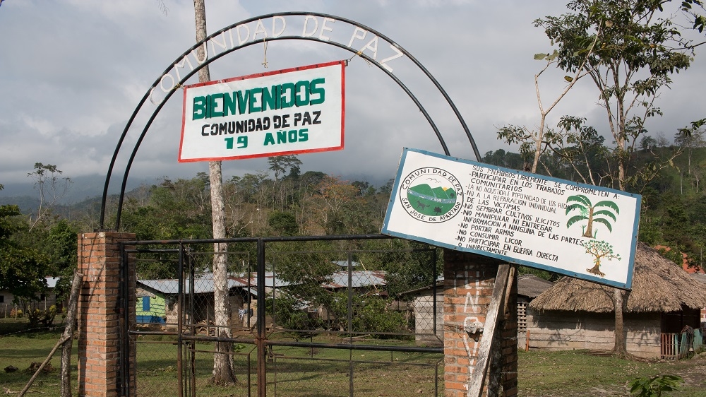 The entrance to the peace community. Rules include not collaborating with any armed groups, including the military [Joe Parkin Daniels/Al Jazeera]