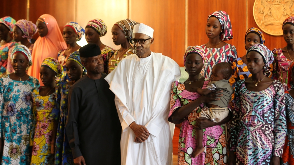 Some of the 21 Chibok schoolgirls released by Boko Haram in October pose with President Muhammadu Buhari and Vice President Yemi Osinbajo [Afolabi Sotunde/Reuters]