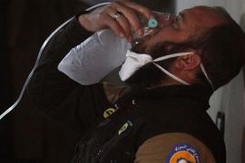 A civil defense member breathes through an oxygen mask, after what rescue workers described as a suspected gas attack in the town of Khan Sheikhoun in rebel-held Idlib