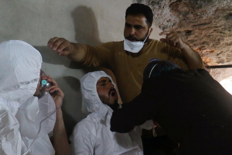 A man breathes through an oxygen mask as another one receives treatments, after what rescue workers described as a suspected gas attack in the town of Khan Sheikhoun in rebel-held Idlib
