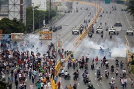 Demonstrators run away from tear gas during clashes with police while rallying against Venezuela''s President Nicolas Maduro in Caracas