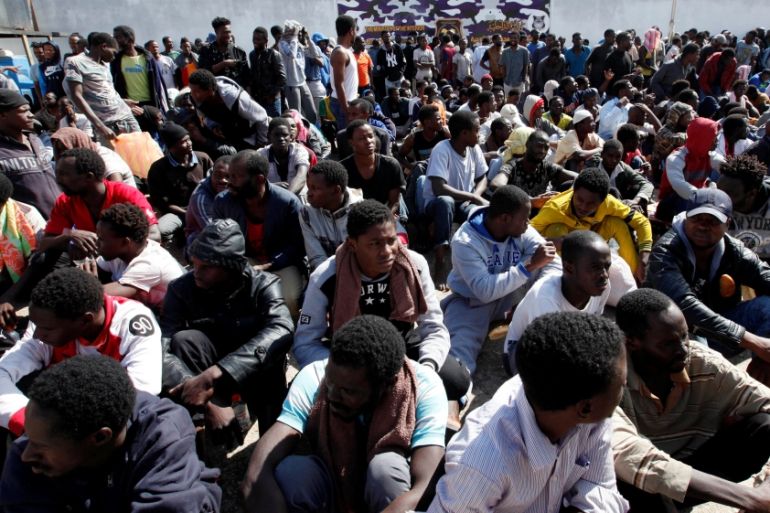 Illegal African migrants sit during a visit by Martin Kobler and William Lacy Swing at a detention camp in Tripoli