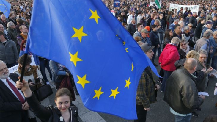 A woman holds European Union flag during a protest in Heroes’ square against a new law that would undermine Central European University in Budapest