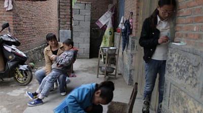 Chen Kaijing with her three children. Chen's adoptive father never married and so she grew up without a mother. Her daughters are now helping her search for her birth parents [Han Meng/Al Jazeera]