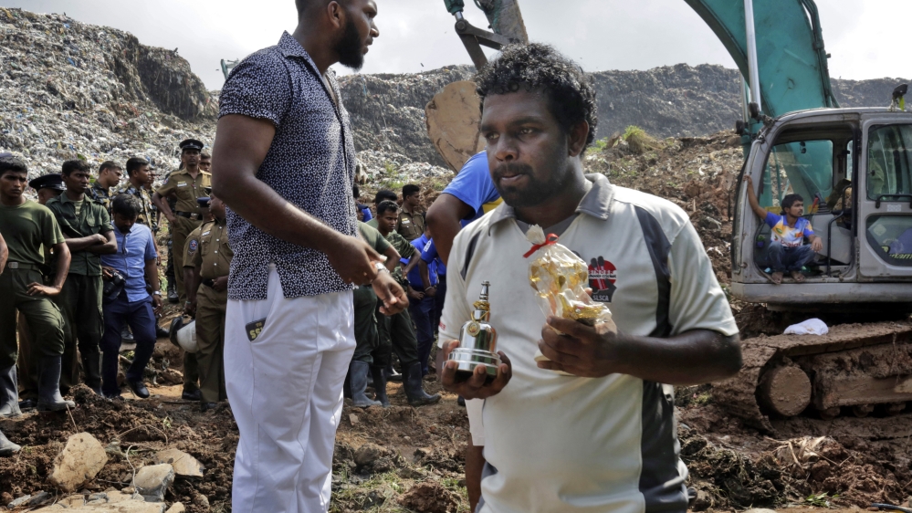 A Sri Lankan man carries several images of deities which once were in his destroyed home [EPA]