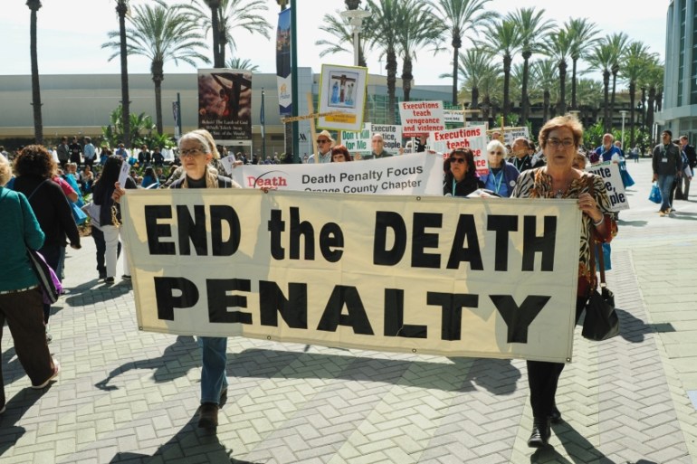 Demonstrators march through a courtyard during a rally protesting against the death penalty and in favor of immigration reform in Anaheim, California