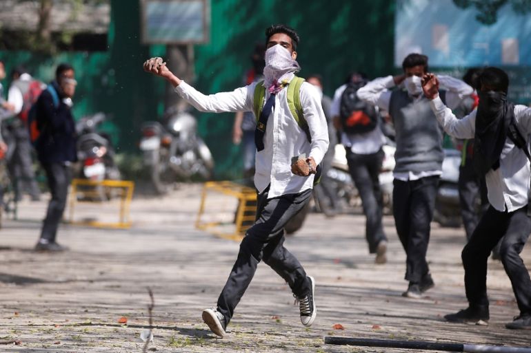 A Kashmiri student throws a piece of stone during a protest in Srinagar