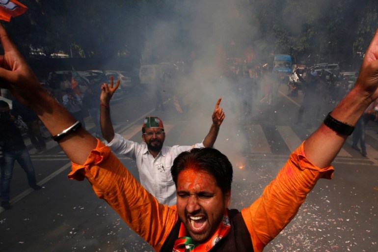 Supporters of India’s Bharatiya Janata Party (BJP) celebrate after learning of the initial poll results outside the party headquarters in New Delhi, India