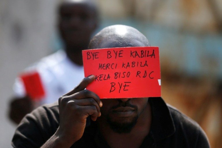 FILE PHOTO: A Congolese opposition party supporter displays a red card against President Joseph Kabila in Kinshasa