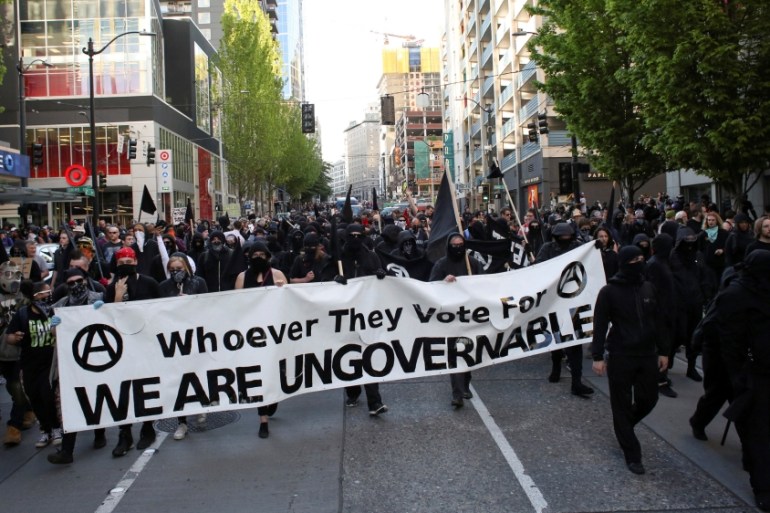 Protesters march through downtown during anti-capitalist protests following May Day marches in Seattle