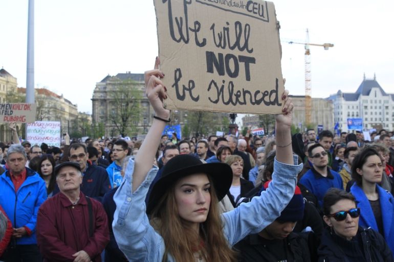 A woman holds a placard as she protests against the bill that would undermine Central European University in Budapest