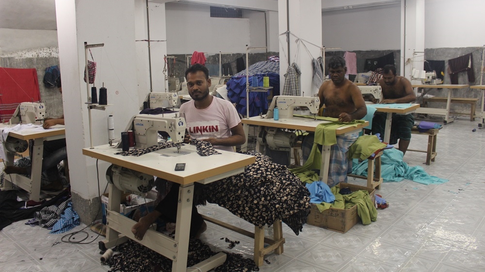 Khadija's husband Habibur sewing in a garment factory in Dhaka. He typically works 12 hours a day in the factory [Neha Thirani Bagri/The GroundTruth Project]