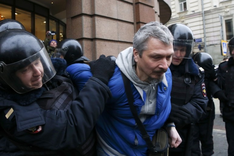 Policemen detain a man during an anti-government protest in Moscow