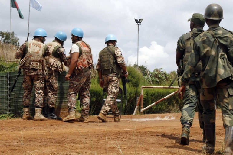 U.N. peacekeepers and members of the Congolese army hold position at the MONUSCO base after dispersing demonstrators in Mavivi