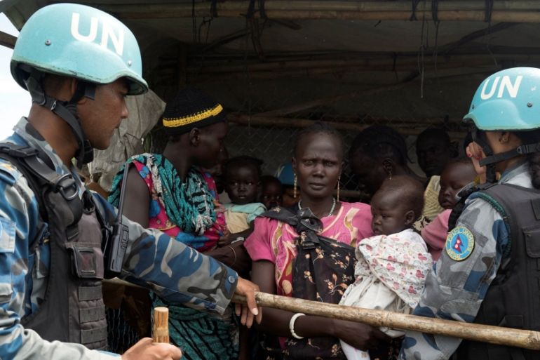 UN peacekeepers control South Sudanese women and children before the distribution of emergency food supplies at the United Nations protection of civilians site 3 hosting about 30,000 people displaced
