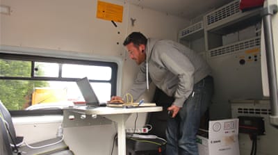 The Refugee Youth Service's Michael McHugh in the charity's new mobile office van, which provides homeless youths in Calais with information about their legal rights and options [Elaine Allaby/Al Jazeera]