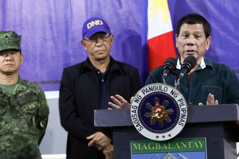Philippine President Rodrigo Duterte speaks to soldiers next to Defence Secretary Delfin Lorenzana and Armed Forces chief General Eduardo Ano during a visit at a military camp in Iligan