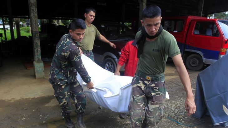 Soldiers carry the body of a civilian killed by insurgents from the so-called Maute group, who has taken over large parts of Marawi City
