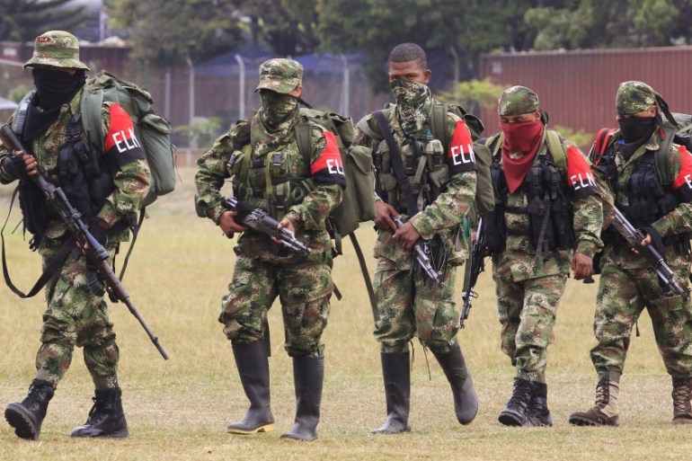 Defected members of Colombian guerrilla group ELN walk to a military base to surrender and handover their weapons, in Cali