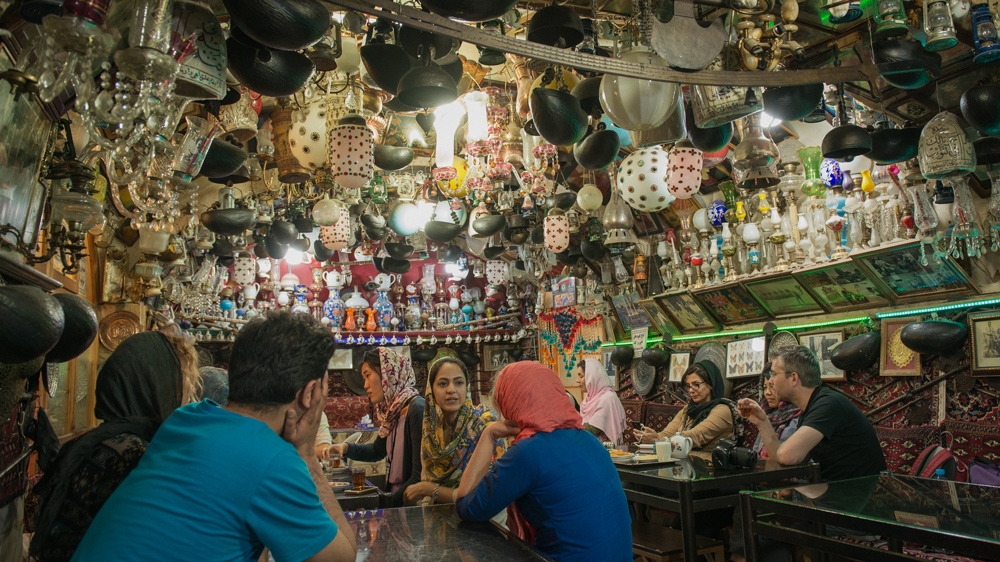 Visitors sip hot drinks and snack on saffron-flavoured treats inside this tea shop in Naqshe Jahan Square [Wojtek Arciszewski/Al Jazeera]