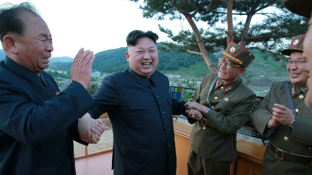 Kim Jong-un reacts with scientists and engineers after Sunday's successful missile launch [KCNA via Reuters]