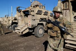 US. army soldiers stand next a military vehicle in the town of Bartella
