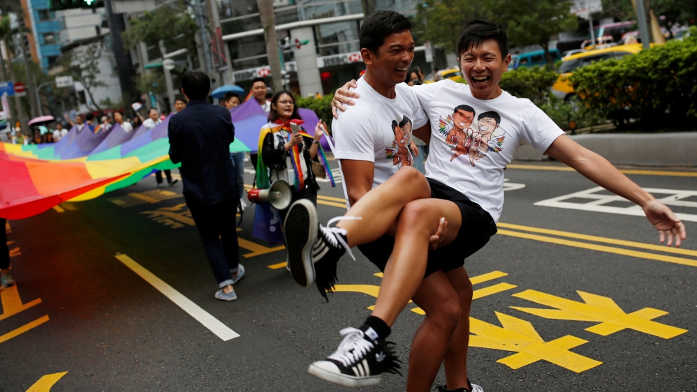A couple poses for photo during an LGBT pride parade in Taipei, Taiwan in October 2016 [Tyrone Siu/Reuters]
