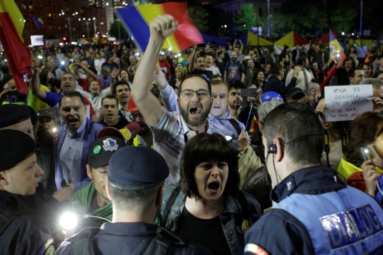 Protesters shout slogans during a demonstration in front of the government building in Bucharest,
