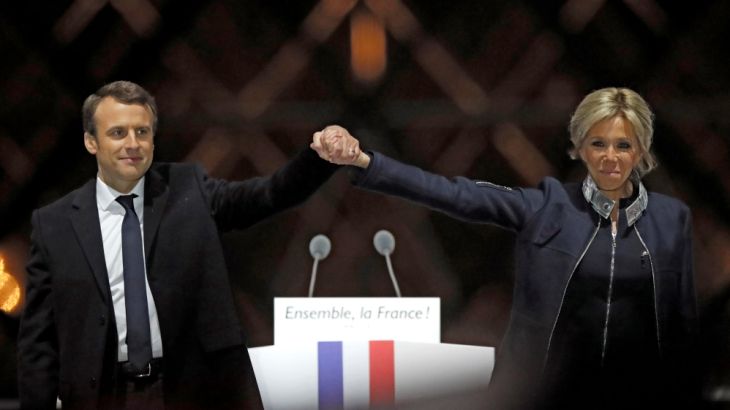 French President elect Emmanuel Macron and his wife Brigitte Trogneux celebrate on the stage at his victory rally near the Louvre in Paris