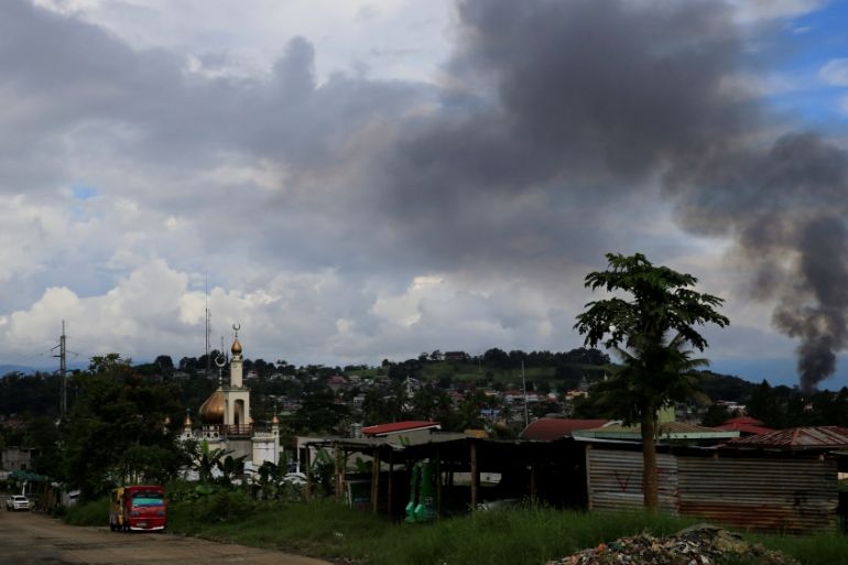 A black smoke comes from a burning building at a Marinaot town, after government troops continuous assault with insurgents from the so-called Maute group, who