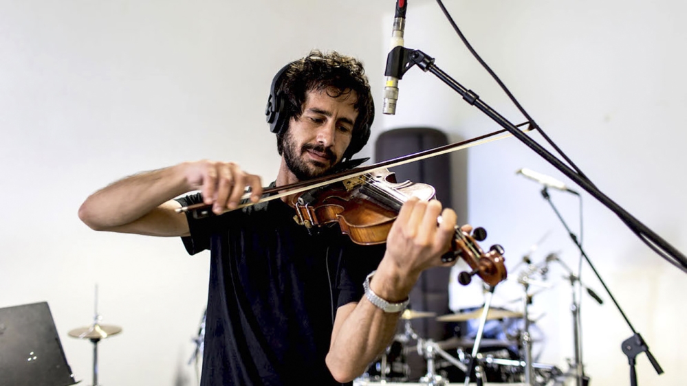 Playing the violin reminds Arsheed of the art space his father ran in his hometown of Sweida, Syria [Marta Bellingreri/Al Jazeera]