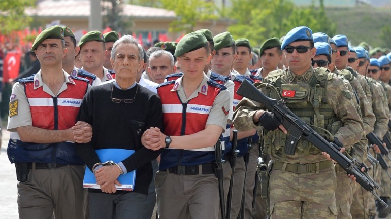 Akin Ozturk, a former Turkish Air Force commander who is accused of plotting and orchestrating last year''s failed coup, is escorted by gendarmes as he arrives at the court in Ankara