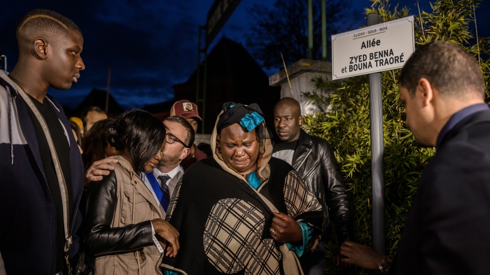Bouna Traore's mother, centre, and relatives inaugurate a street sign commemorating the two teenagers in 2015 [Christophe Petit Tesson/EPA/File]