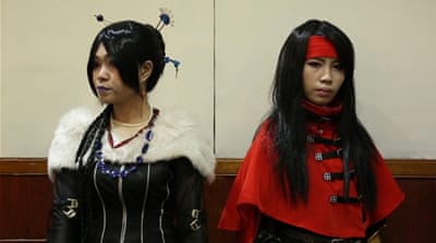 Hafizah (left) and her sister participate in a cosplay event in December. Hafizah wears the hijab but uses wigs to cover her hair during cosplay. [Preeti Jha/Al Jazeera]