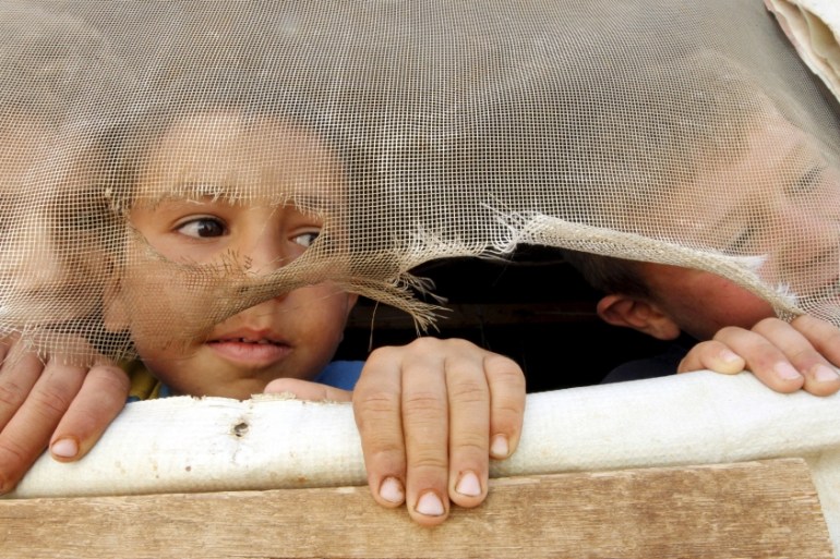 FILE PHOTO: Syrian refugee children look out from their tent in Saadnayel in Lebanon''s Bekaa Valley