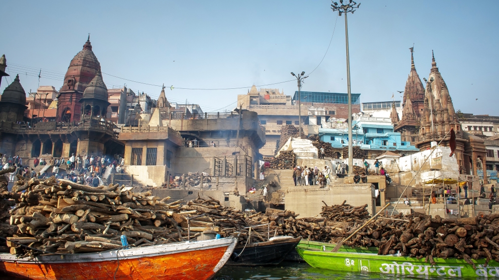 
Boats loaded with wood for funeral pyres sit in front of Manikarnika Ghat where hundreds of corpses are cremated every day. [Radhika Iyengar/Al Jazeera]
