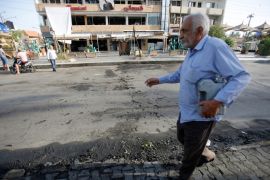 An Iraqi man walks past the site of a car bomb exploded near a cafe in Baghdad