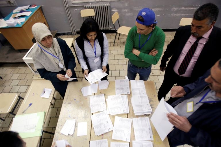 Election workers count ballots at the end of voting for the parliamentary election in Algiers
