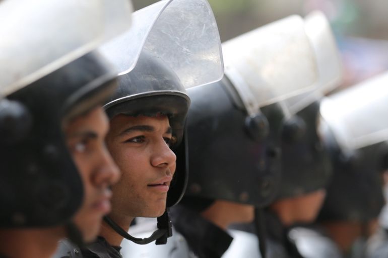 Riot police officers stand during a protest against restrictions on the press and to demand the release of detained journalists, in front of the Press Syndicate in Cairo