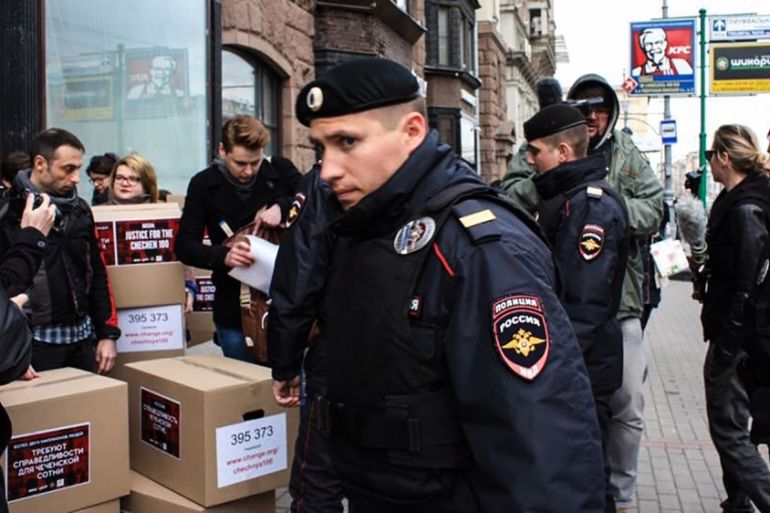 Russian policemen surround Russian gay-rights activists standing next to boxes alledgedly containing signed petitions calling for a probe into a reported crackdown on Chechnya''s LGBT community