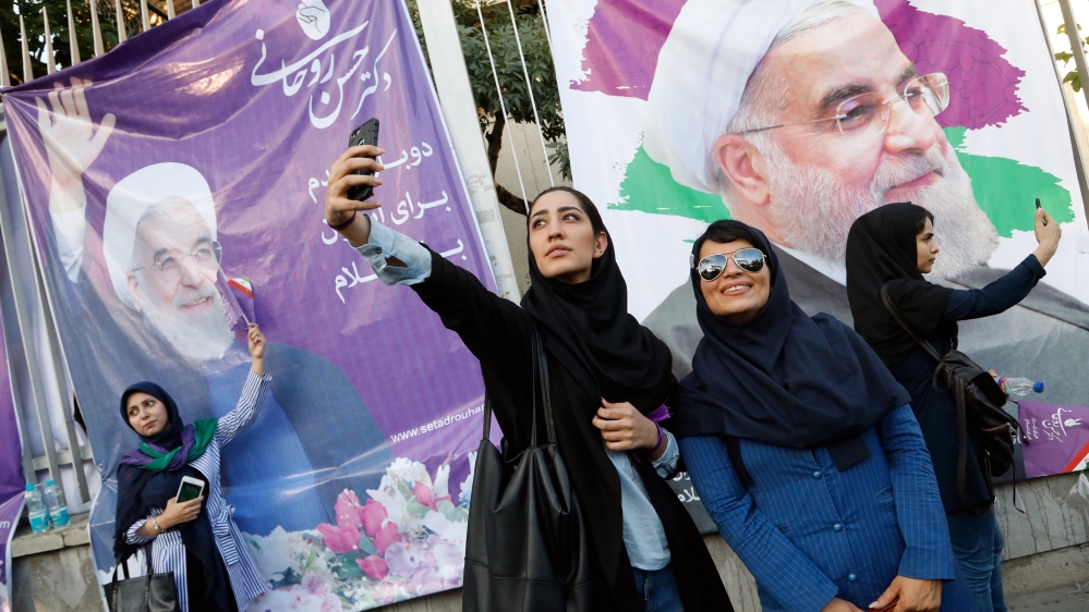 Supporters of Iranian president and presidential candidate Hassan Rouhani pose for pictures during an election camping rally in Tehran, Iran [EPA]